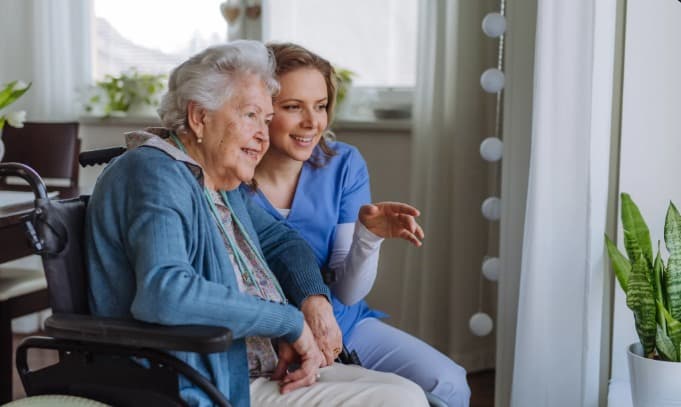 Support worker sitting with an older wheelchair user