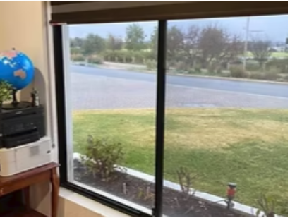 View through sliding glass doors to the street and front lawn